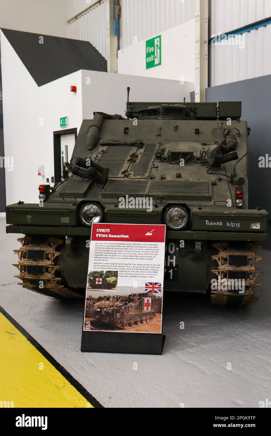 Un véhicule blindé vert militaire de style militaire se trouve dans un garage, le sol sous lui est marqué d'un panneau Banque D'Images