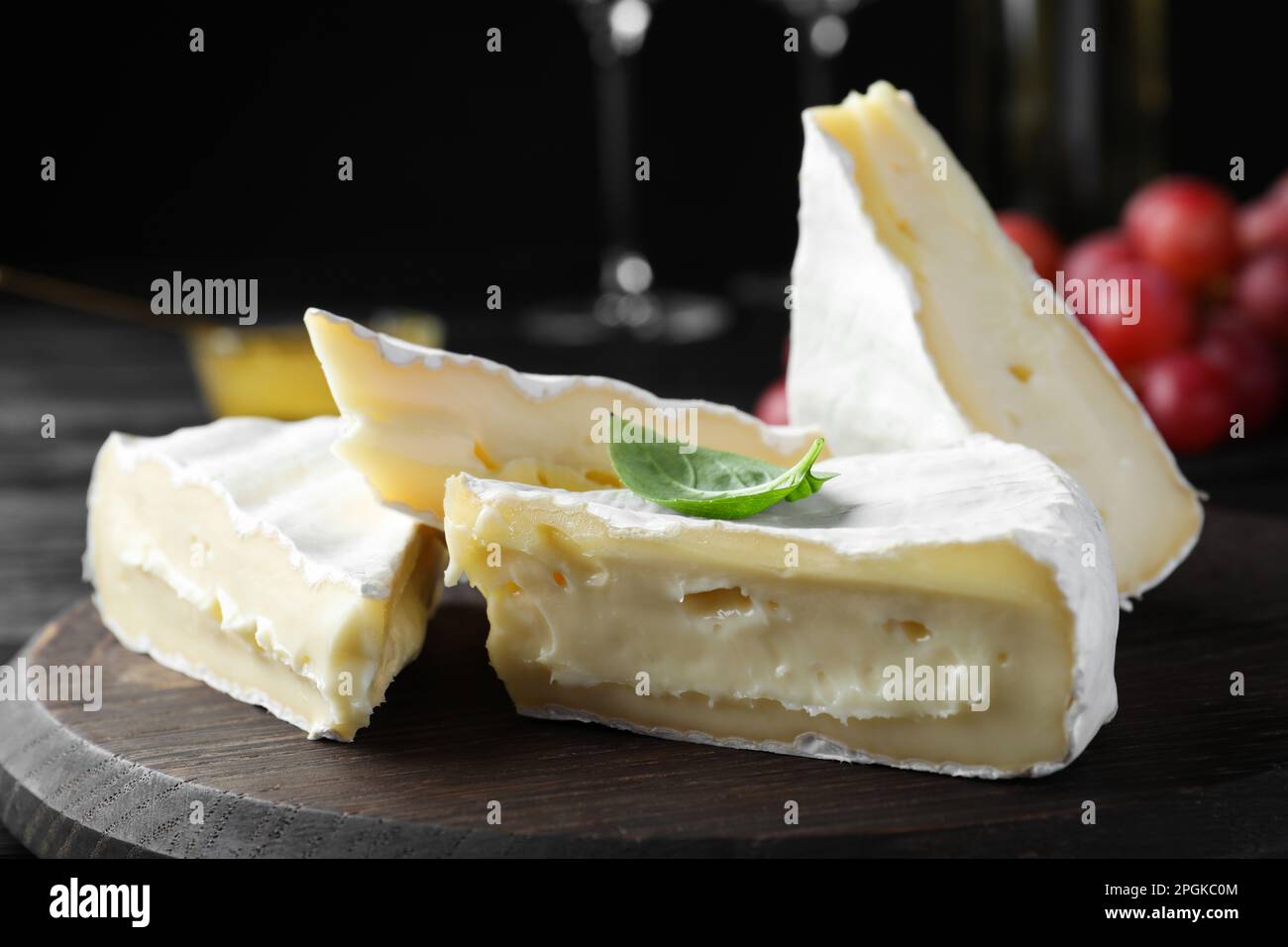 Savoureux fromage brie au basilic sur panneau en bois, gros plan Banque D'Images