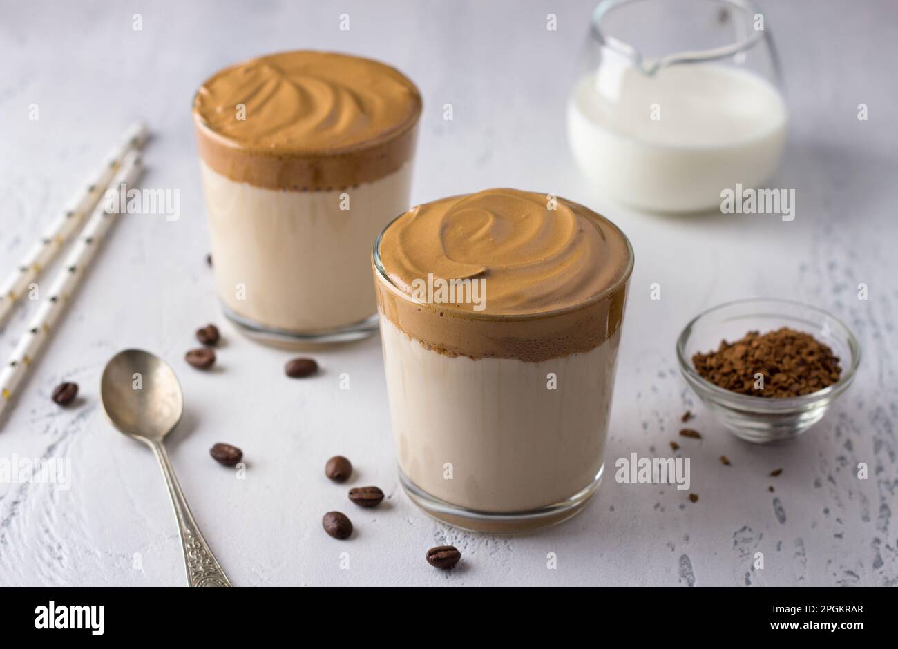 Deux verres avec café Dalgona, cocktail froid avec mousse de café fouettée, boisson tendance populaire sur un fond texturé clair Banque D'Images