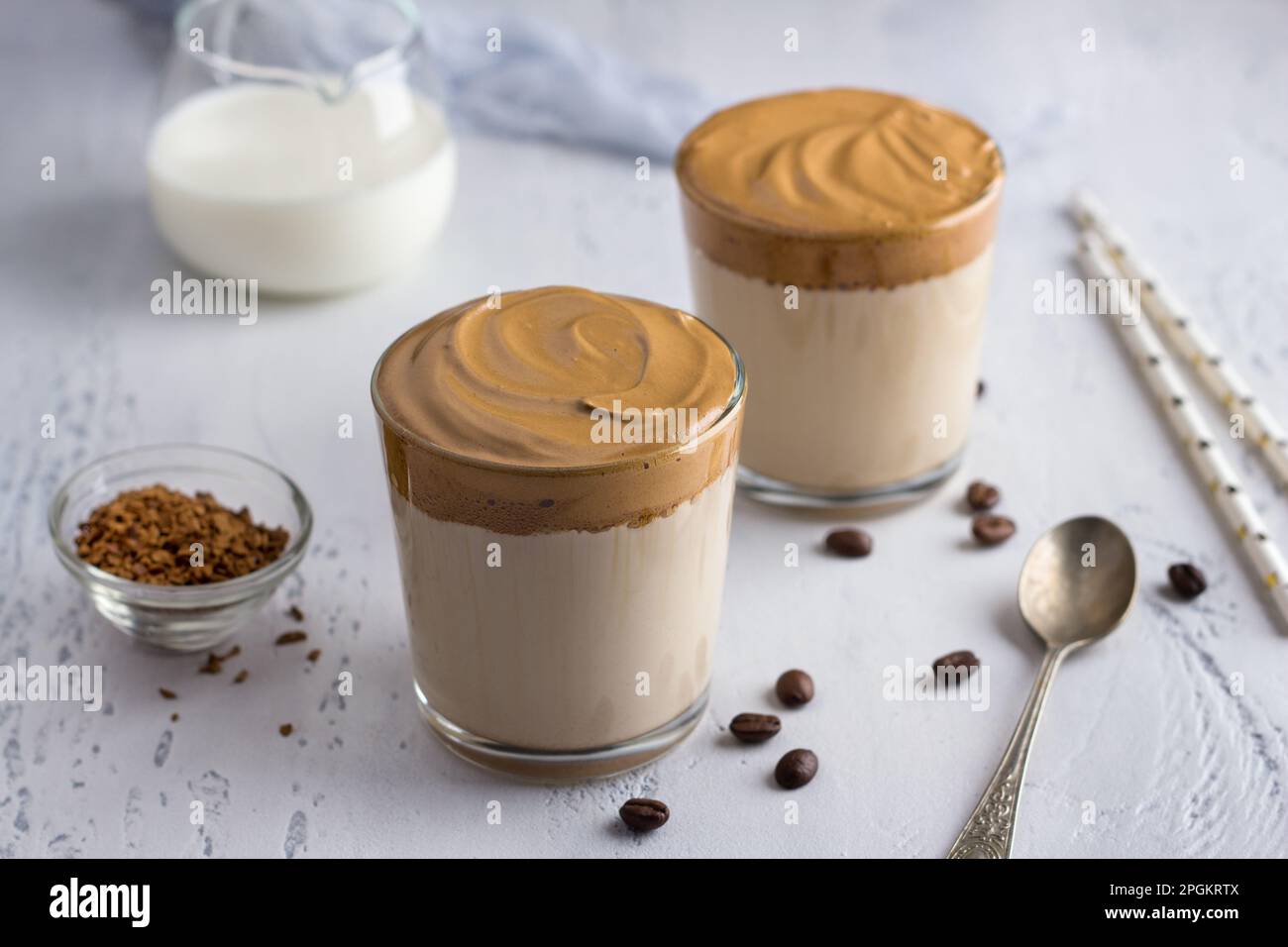 Deux verres avec café Dalgona, cocktail froid avec mousse de café fouettée, boisson tendance populaire sur un fond texturé clair Banque D'Images