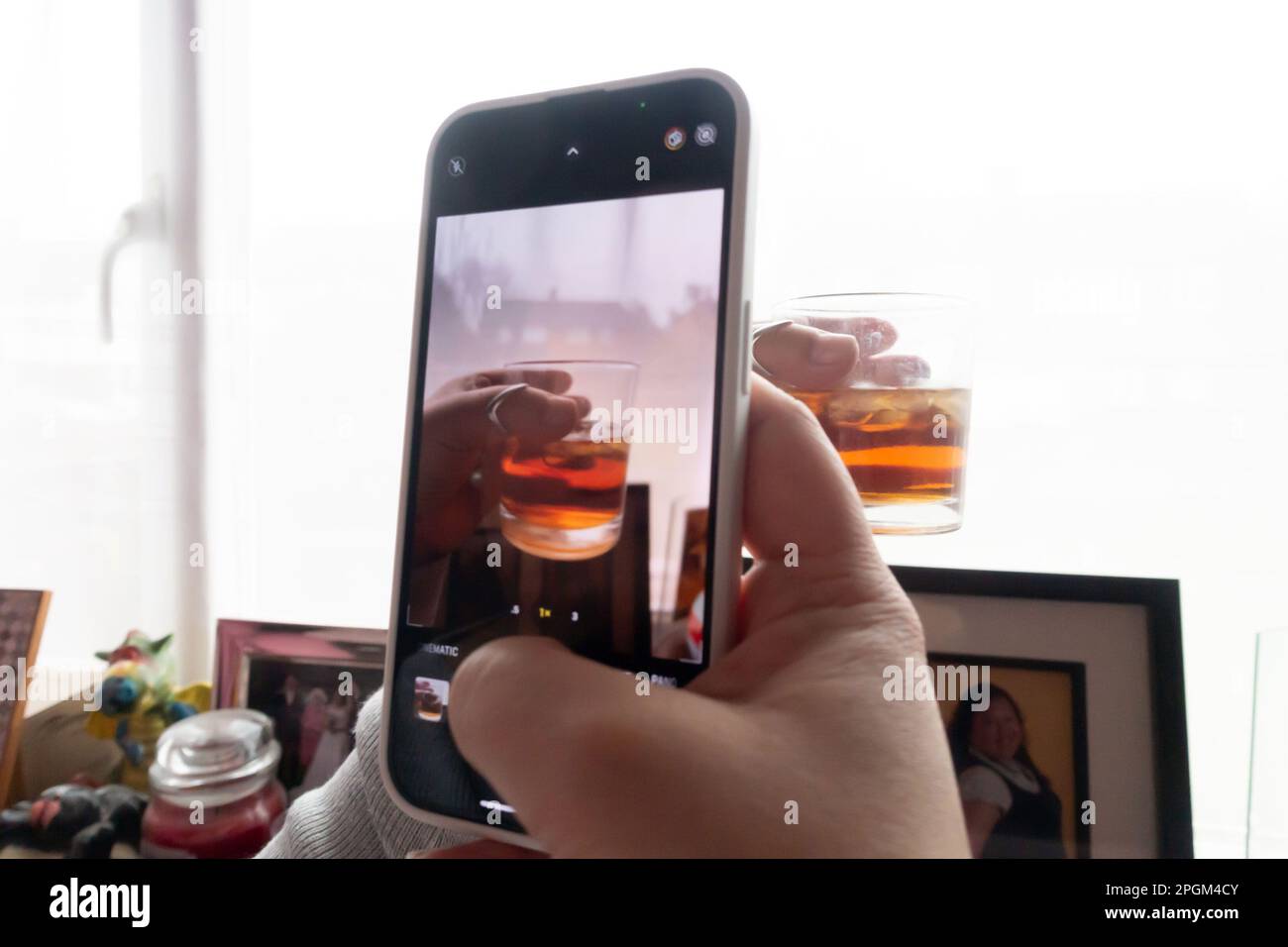 Une dame prend une photo de sa boisson alcoolisée avec son téléphone portable o partager sur les médias sociaux Banque D'Images
