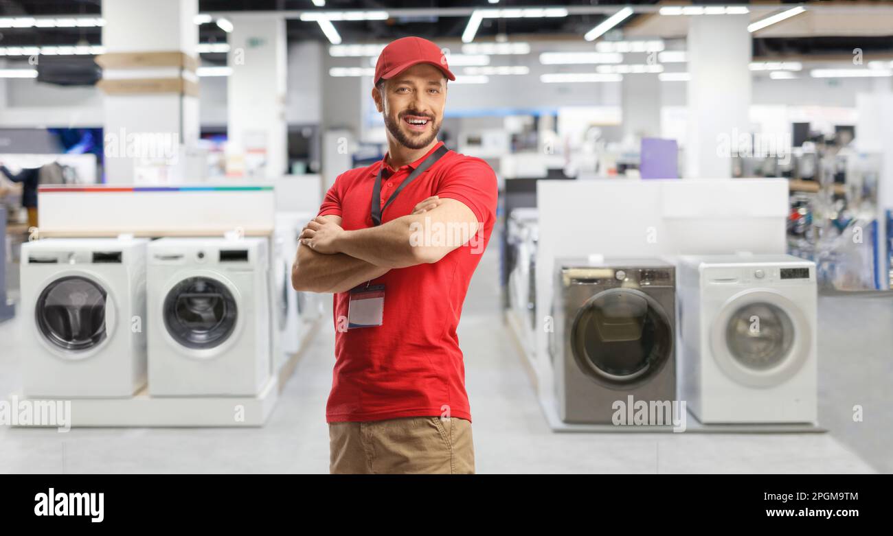 Le directeur des ventes pose dans un atelier d'appareils électriques avec des machines à laver Banque D'Images