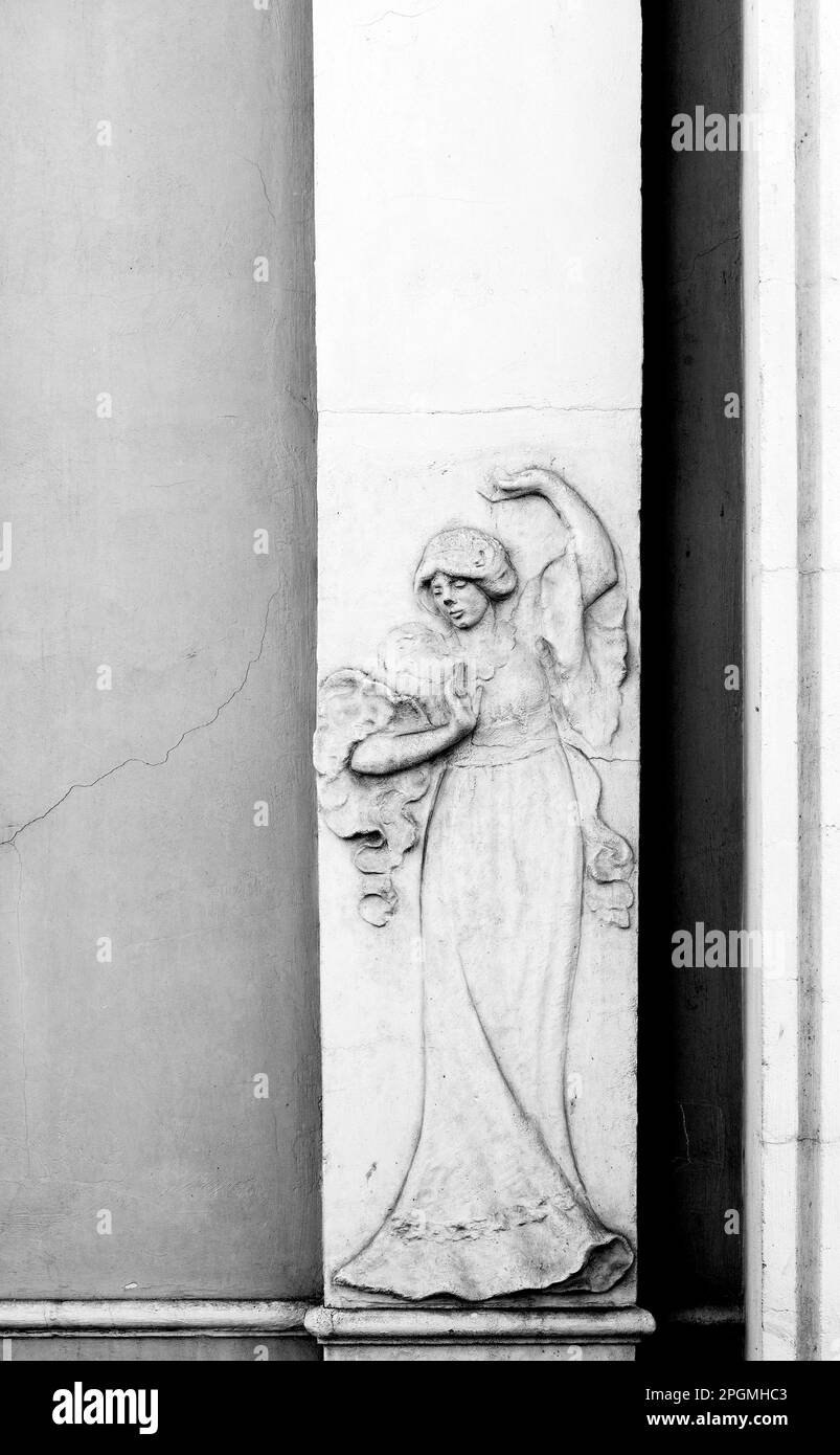 Tourné en couleur et en noir et blanc sur la façade de ce bâtiment historique représentant un caractère, un animal ou une fleur. Situé à Barcelone Banque D'Images