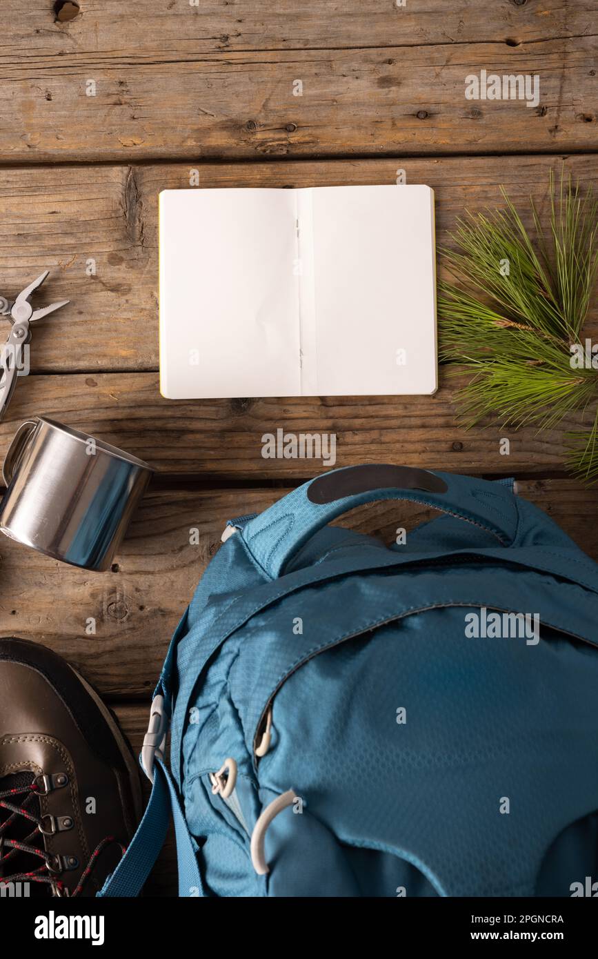 Équipement de camping de sac à dos, tasse en métal et carnet vierge sur fond en bois avec espace pour copier Banque D'Images
