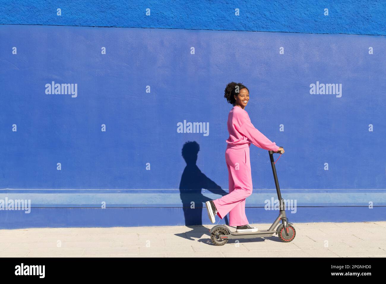 Bonne femme à bord d'un scooter électrique par beau temps Banque D'Images