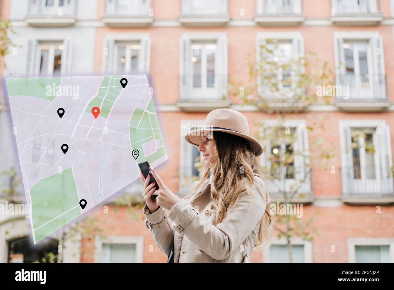 Femme qui navigue avec un smartphone devant le bâtiment Banque D'Images