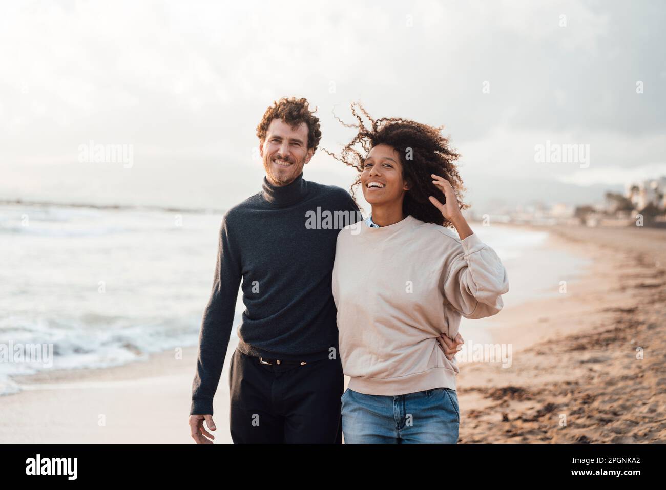 Homme et femme heureux marchant ensemble à la plage Banque D'Images Homme et femme heureux marchant ensemble à la plage Banque D'Images