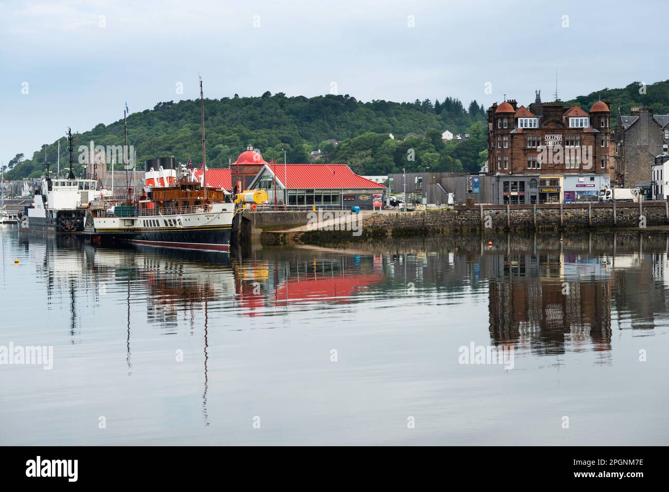Argyll Ecosse. Bateau à aubes Waverley amarré dans le port d'Oban avec la ville et des bateaux de pêche Banque D'Images