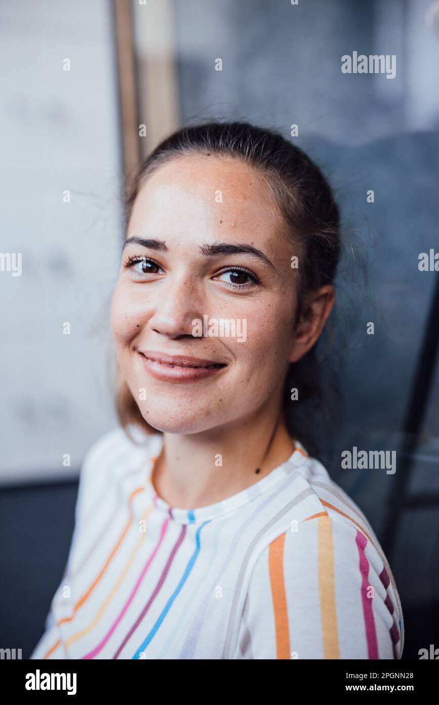 Smiling businesswoman sitting in office Banque D'Images