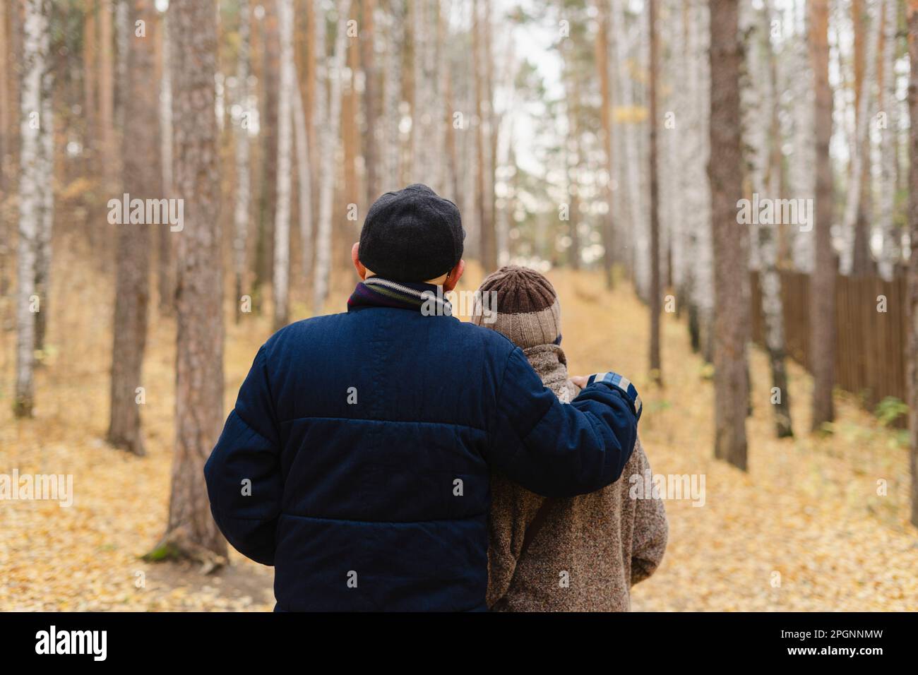 Homme âgé avec le bras autour de la femme regardant les arbres dans le parc Banque D'Images