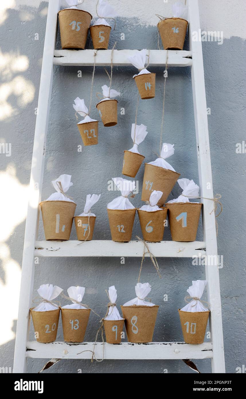 Calendrier de l'Avent DIY fait de pots de fleurs suréparées debout sur des marches d'échelle Banque D'Images