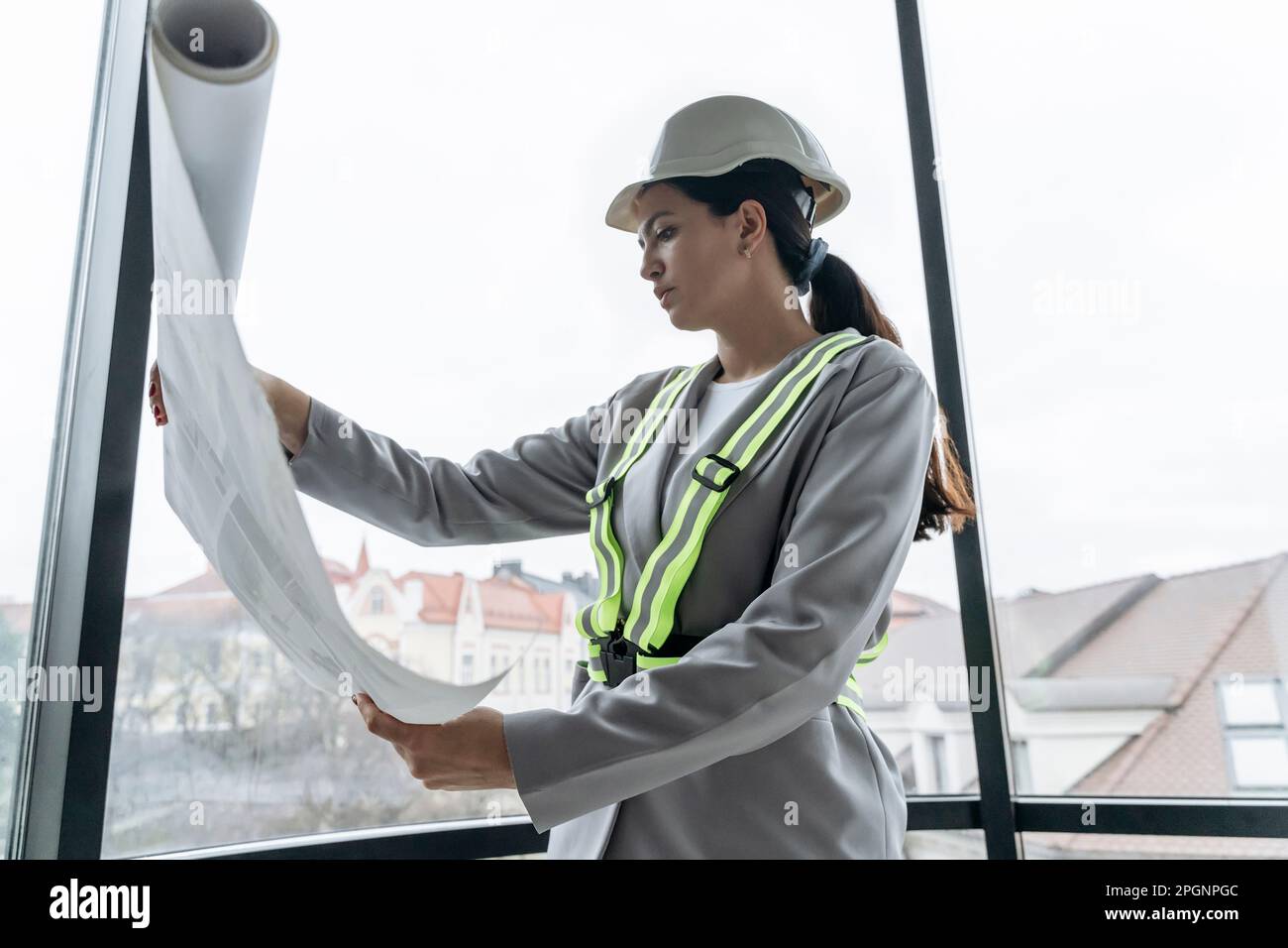 Architecte traversant le plan près de la fenêtre au bureau Banque D'Images