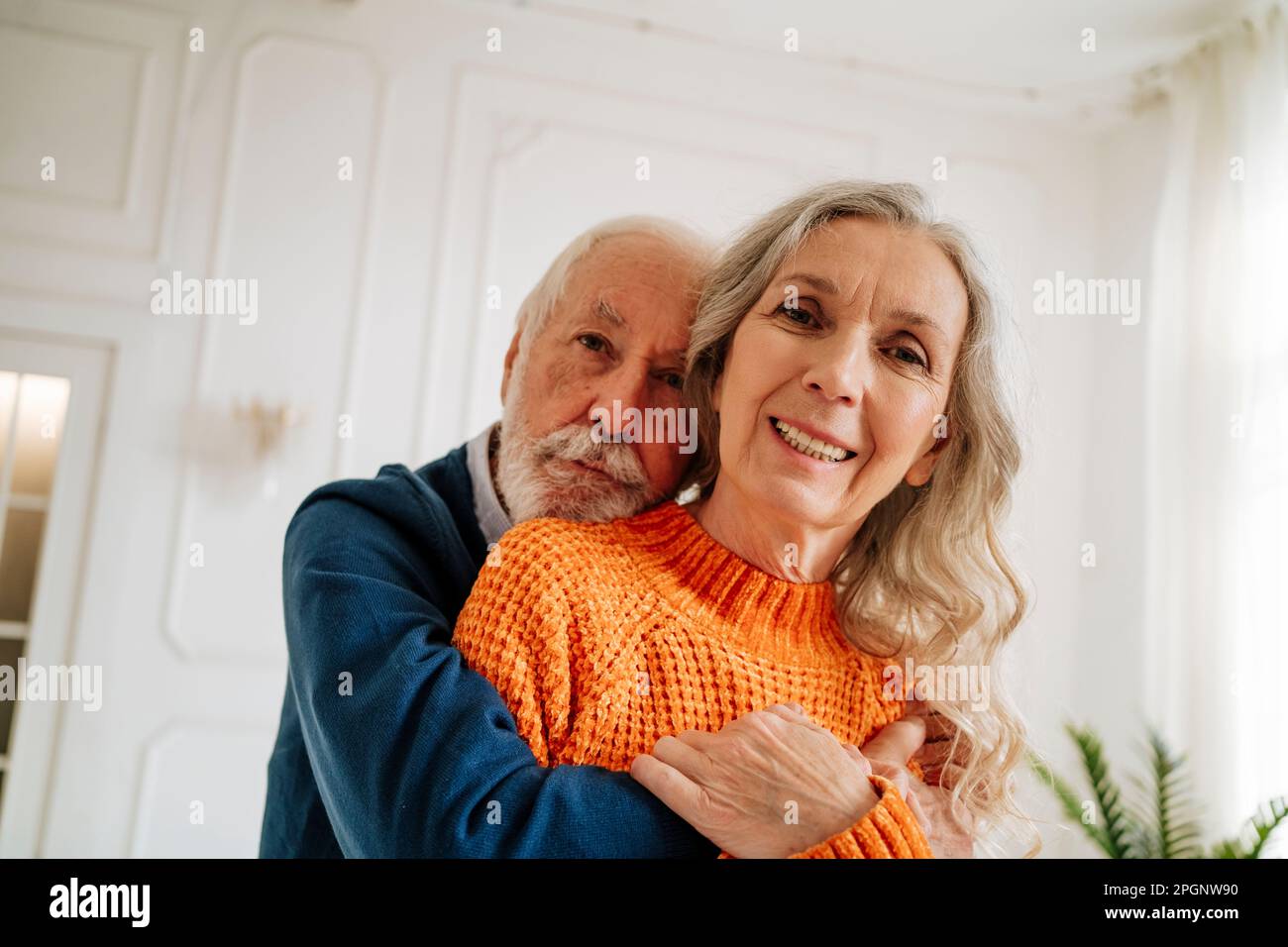 Couple senior aimant s'embrassant les uns les autres à la maison Banque D'Images