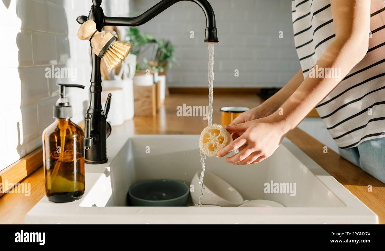 Fille lavant loofah dans le lavabo à la maison Banque D'Images