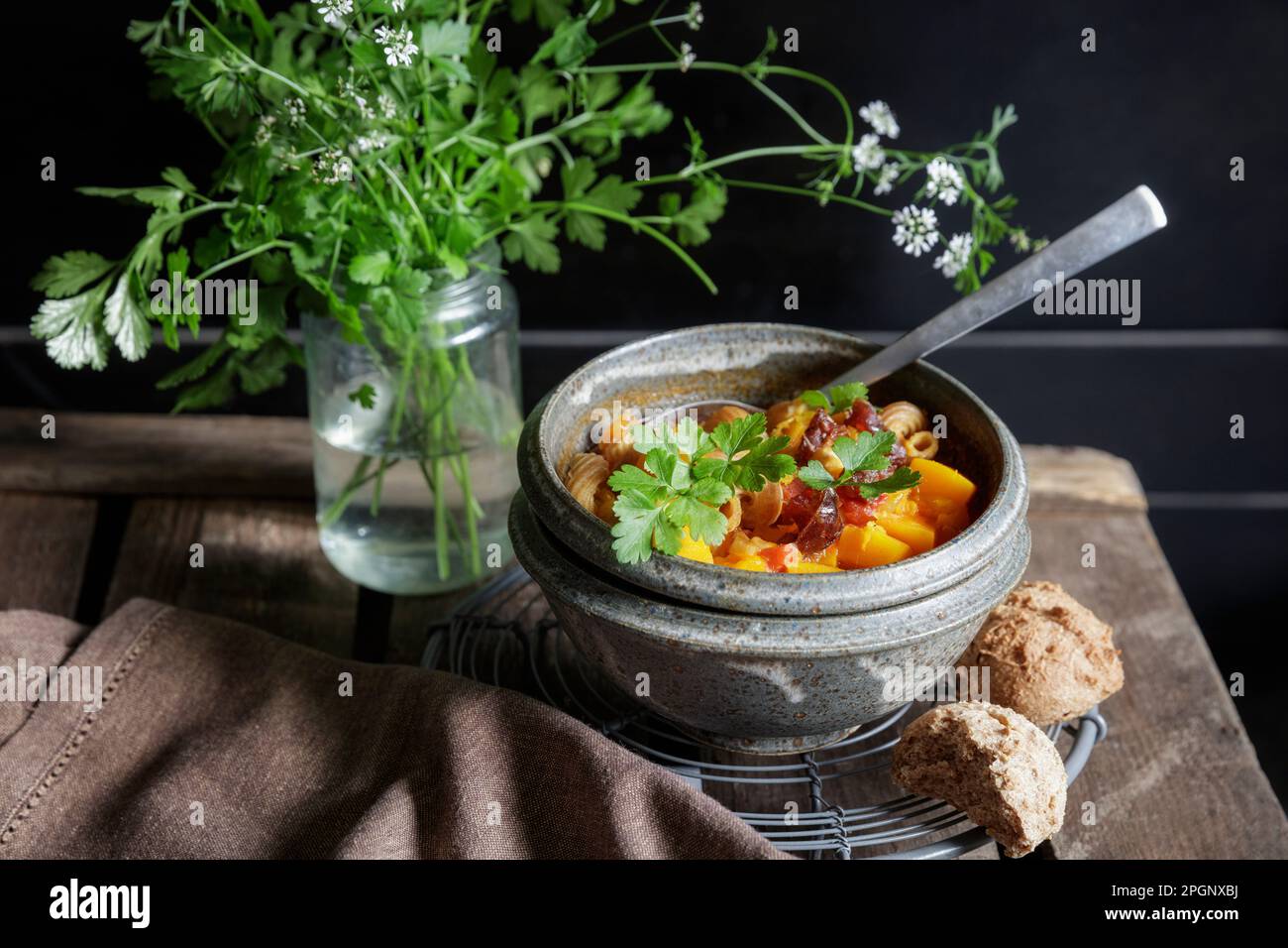 Photo studio d'un bol de ragoût nord-africain prêt à manger avec potiron, pois chiches, lentilles, dattes et coriandre Banque D'Images