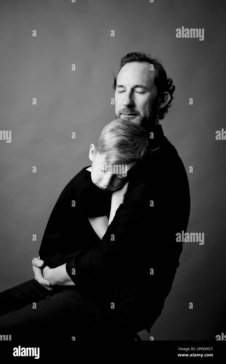 Père affectueux avec les yeux fermés embrassant son fils Banque D'Images