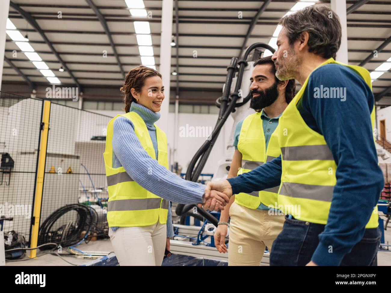 Un ingénieur se secouant la main avec un collègue en usine Banque D'Images