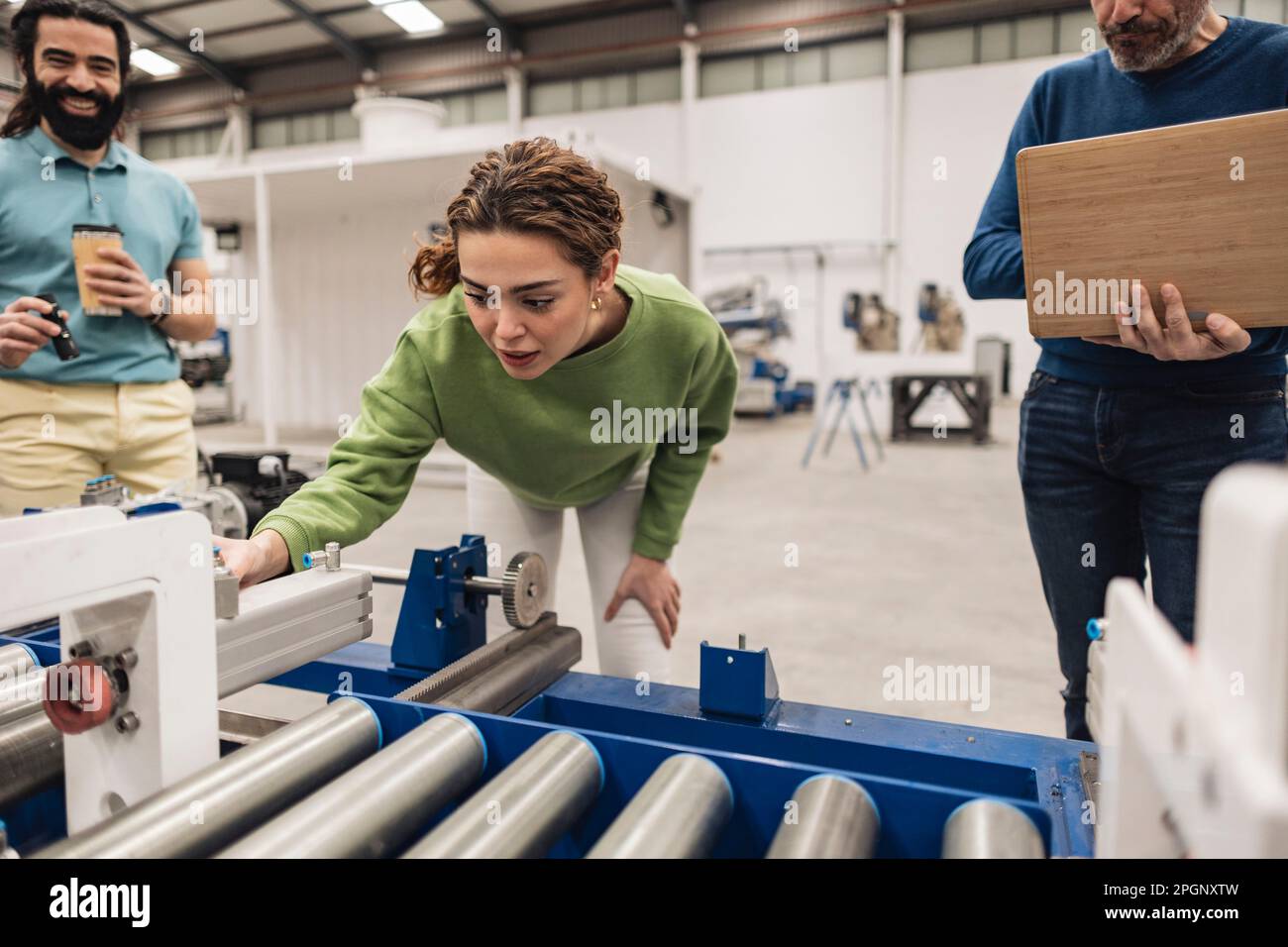 Ingénieur analysant le tapis convoyeur avec des collègues de l'usine robotique Banque D'Images