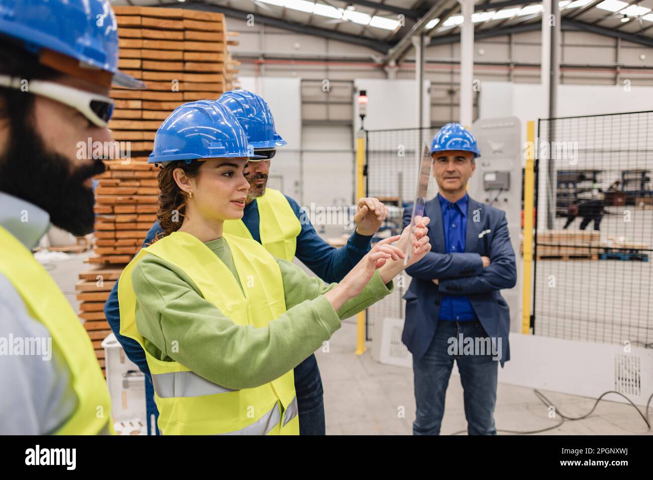 Ingénieur utilisant l'écran tactile avec des collègues de l'usine robotique Banque D'Images