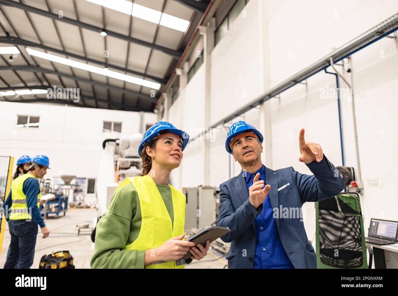 Des ingénieurs souriants qui discutent dans une usine de robotique Banque D'Images