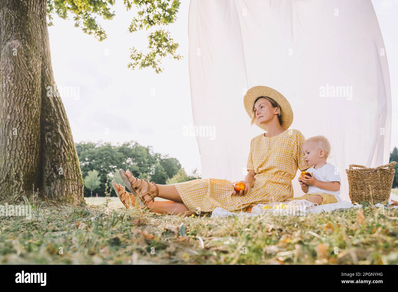 Femme attentionnés assise avec son fils dans le parc Banque D'Images