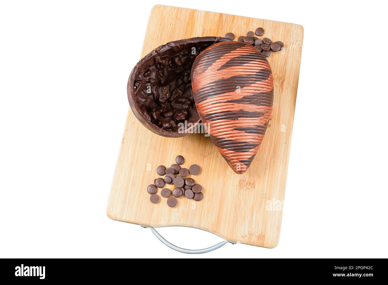 Œuf de Pâques au chocolat amer aux amandes croquantes, sur une planche de bois. Entouré de noix de Saint-Jacques au chocolat. Banque D'Images
