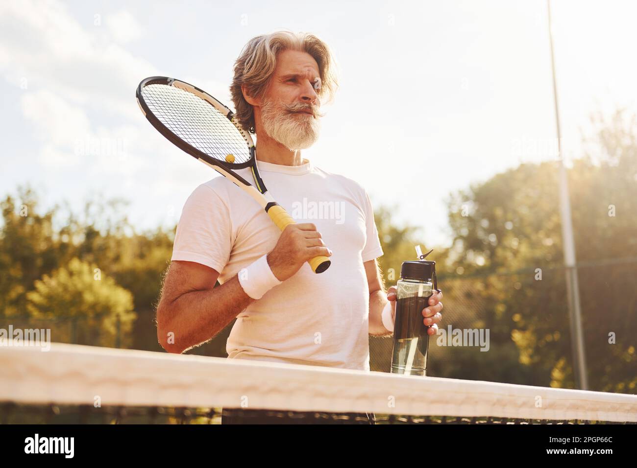Raquette de maintien. Homme de style moderne senior avec raquette en plein  air sur un court de tennis en journée Photo Stock - Alamy