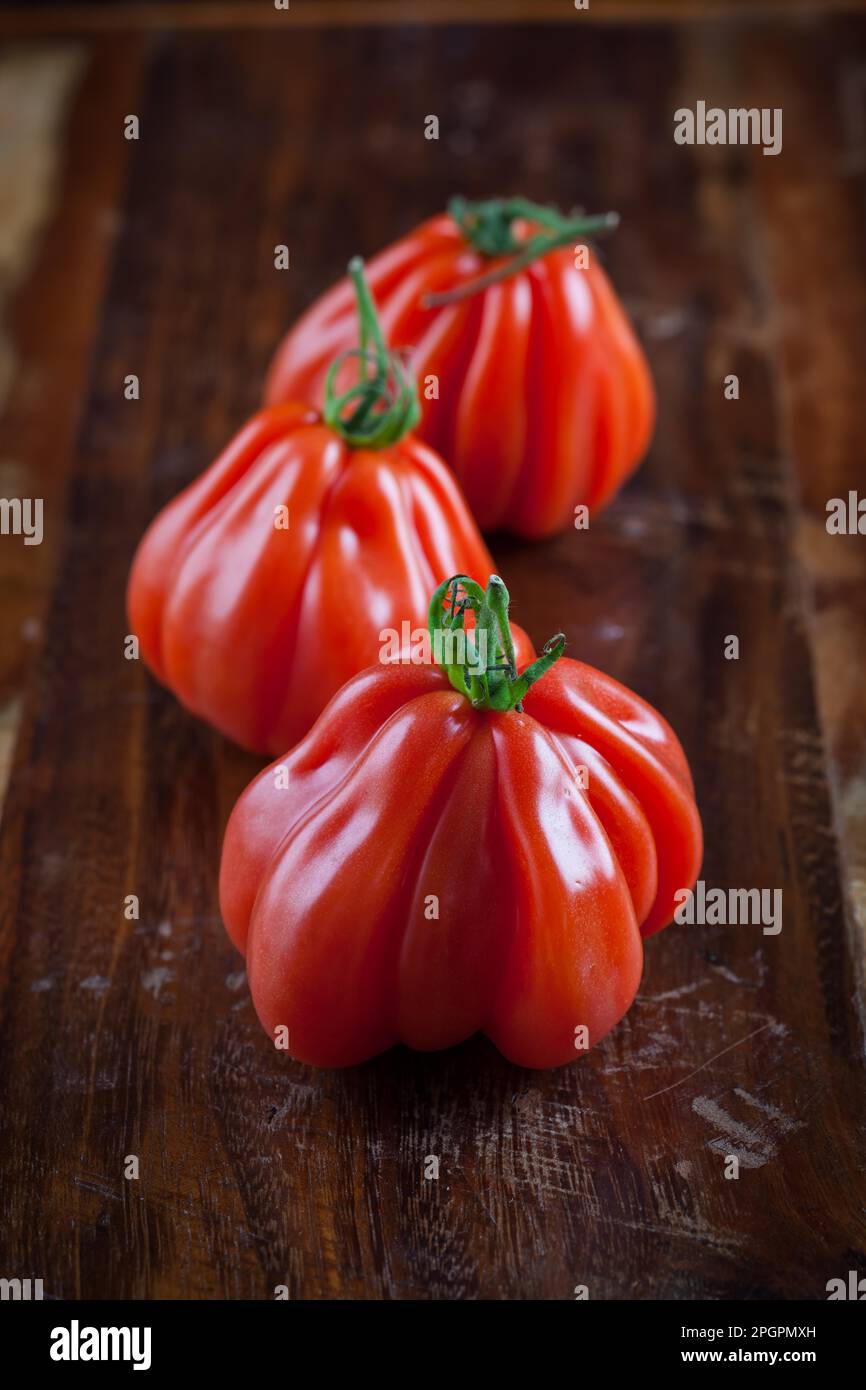 Tomates de bœuf fraîches sur une table en bois Banque D'Images