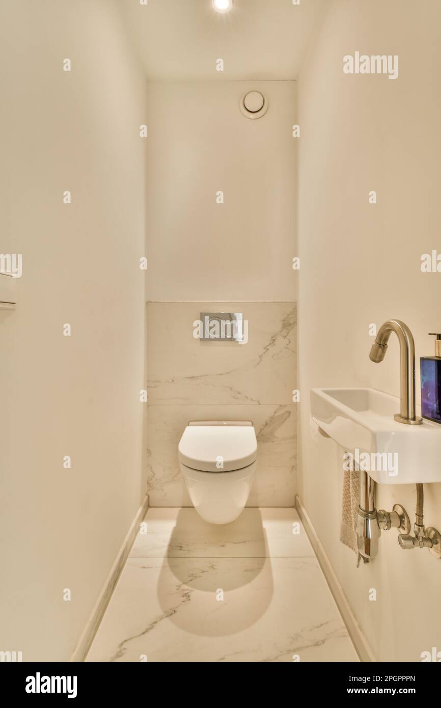 une salle de bains avec toilettes, lavabo et miroir sur le mur dans son  coin droit à gauche Photo Stock - Alamy