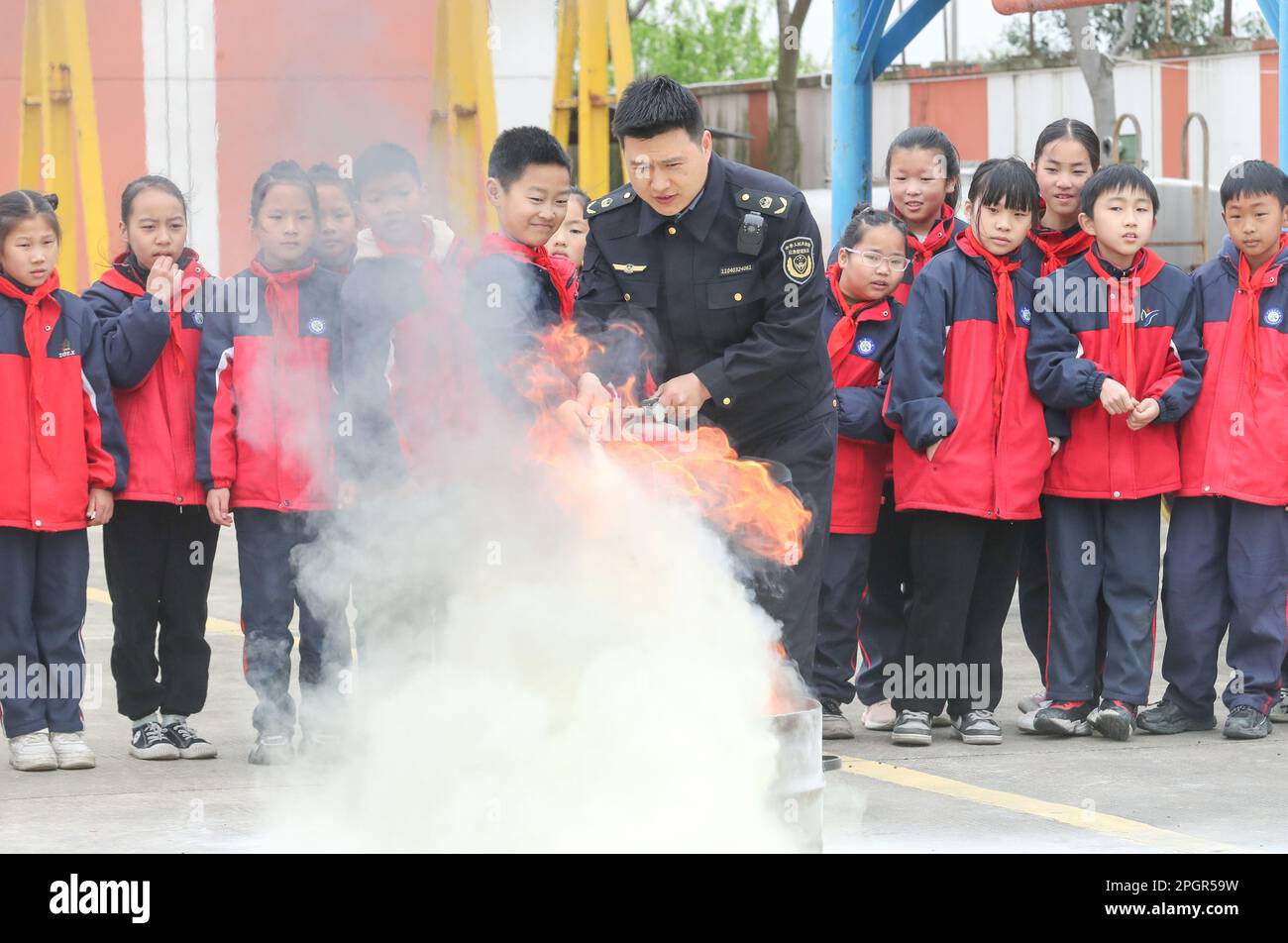 HUZHOU, CHINE - 24 MARS 2023 - Un membre du personnel du poste de gestion des urgences informe les étudiants sur la façon d'utiliser correctement les extincteurs des ZH Banque D'Images