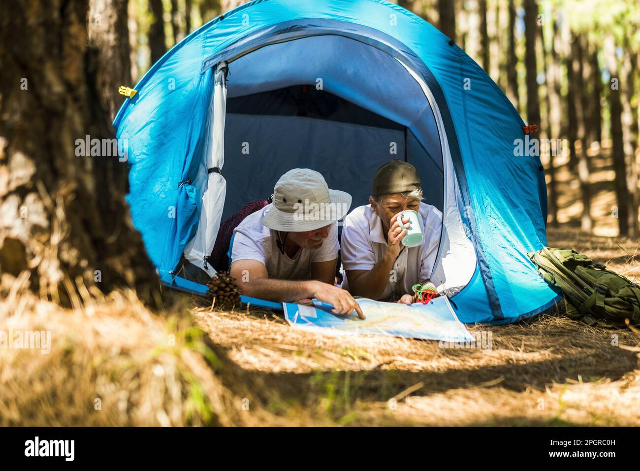 Portrait d'un couple senior se relaxant à l'intérieur d'une tente dans le camping libre bois alternative voyage mode de vie de vacances. L'homme et la femme âgés d'âge mûr aiment ensemble Banque D'Images