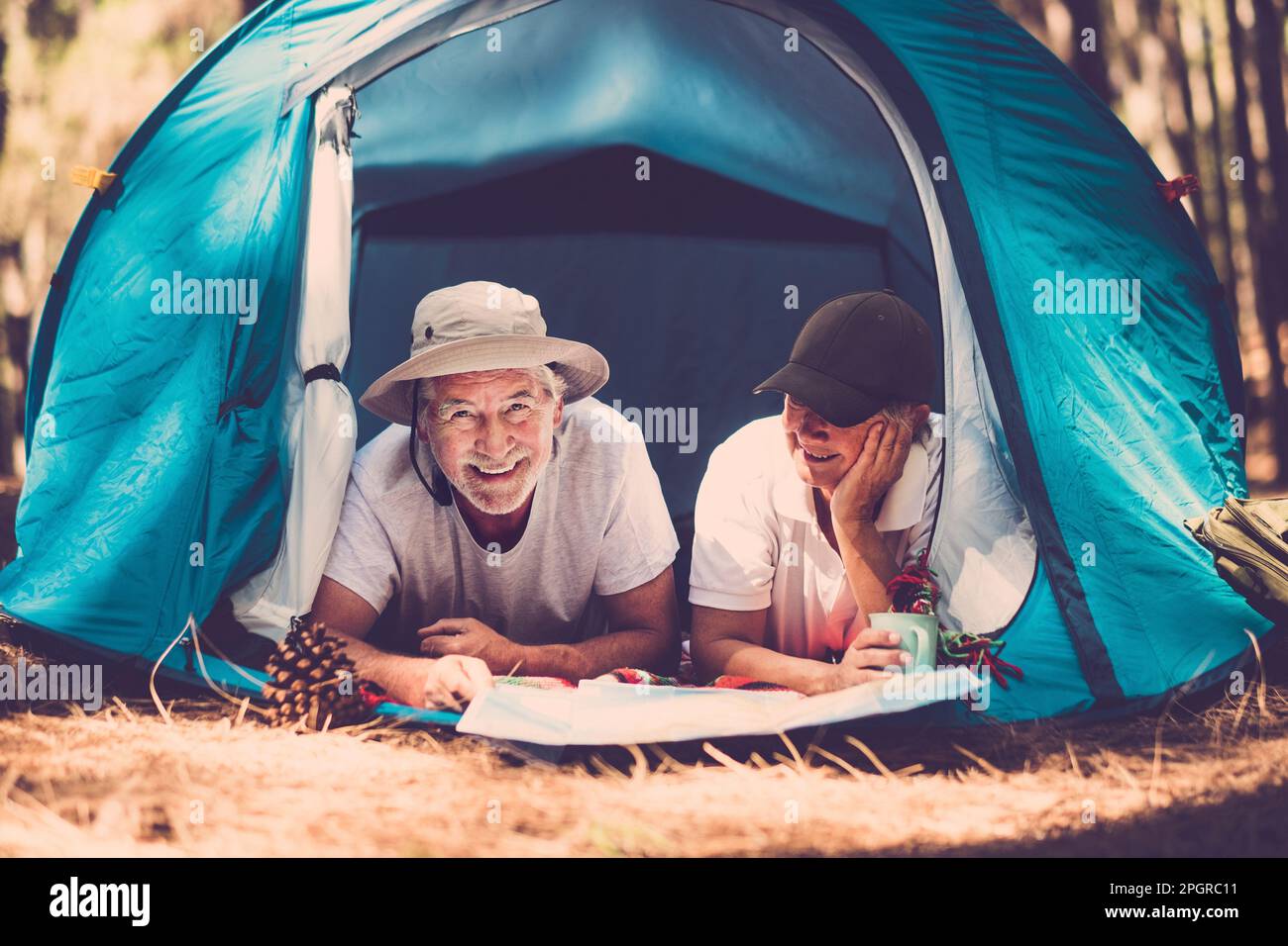 Portrait d'un couple senior se relaxant à l'intérieur d'une tente dans le camping libre bois alternative voyage mode de vie de vacances. L'homme et la femme âgés d'âge mûr aiment ensemble Banque D'Images