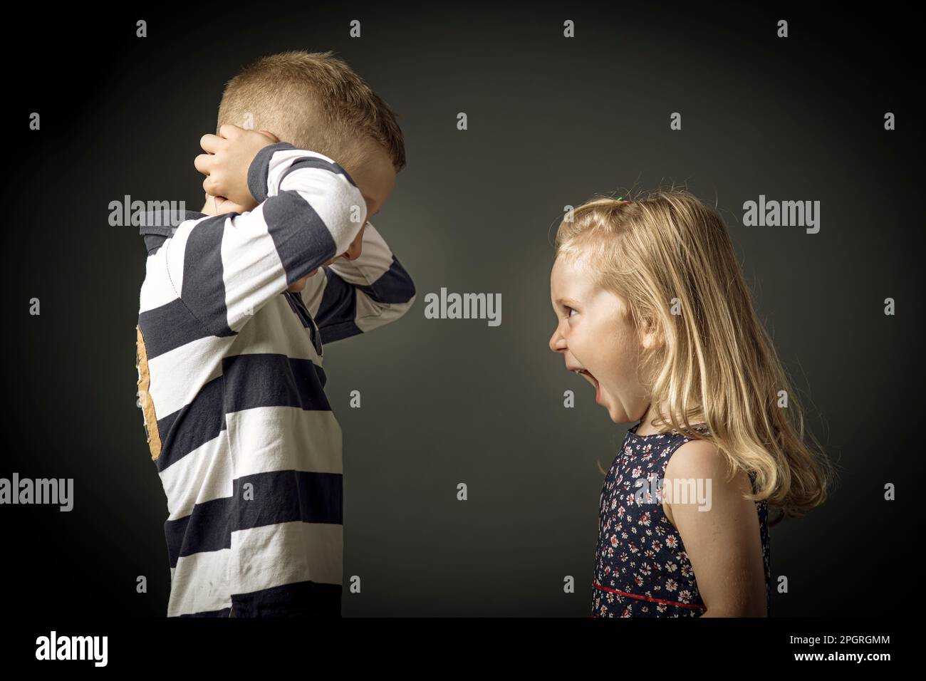 l'enfant crie et l'enfant bouche ses oreilles pour ne pas entendre Banque D'Images