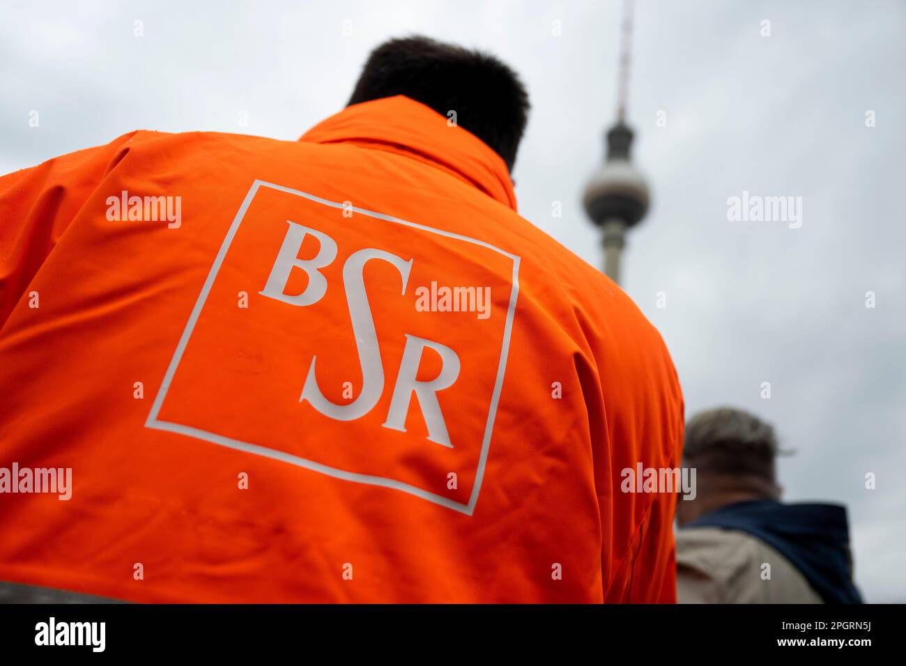 Berlin, Allemagne. 24th mars 2023. Un employé frappant du service de  nettoyage municipal de BSR de Berlin se tient à un rassemblement. Le  syndicat Verdi a appelé à des grèves d'avertissement dans
