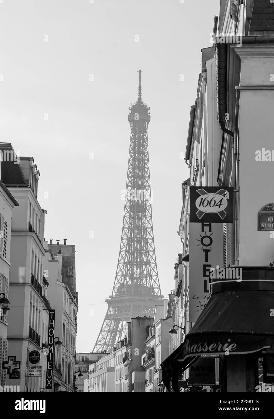 PARIS, FRANCE - 12 MARS 2016 : Tour Eiffel vue dans la brume de la rue parisienne typique avec des cafés et des hôtels. Photo historique noir et blanc. Banque D'Images