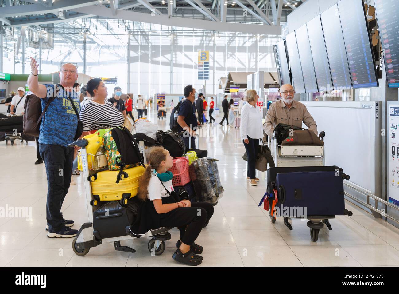 Bangkok, Thaïlande - 19 janvier 2023 : touristes étrangers de famille vérifiant les horaires de vol de départ et d'arrivée à l'aéroport de suvarnabhumi. Banque D'Images