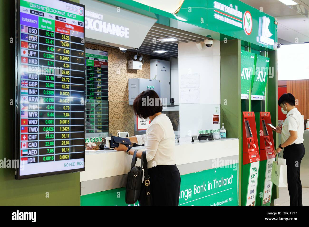 Bangkok, Thaïlande - 1 février 2023 : voyageur d'affaires asiatique en banque au guichet de change de l'aéroport de suvarnabhumi avec disp de change Banque D'Images