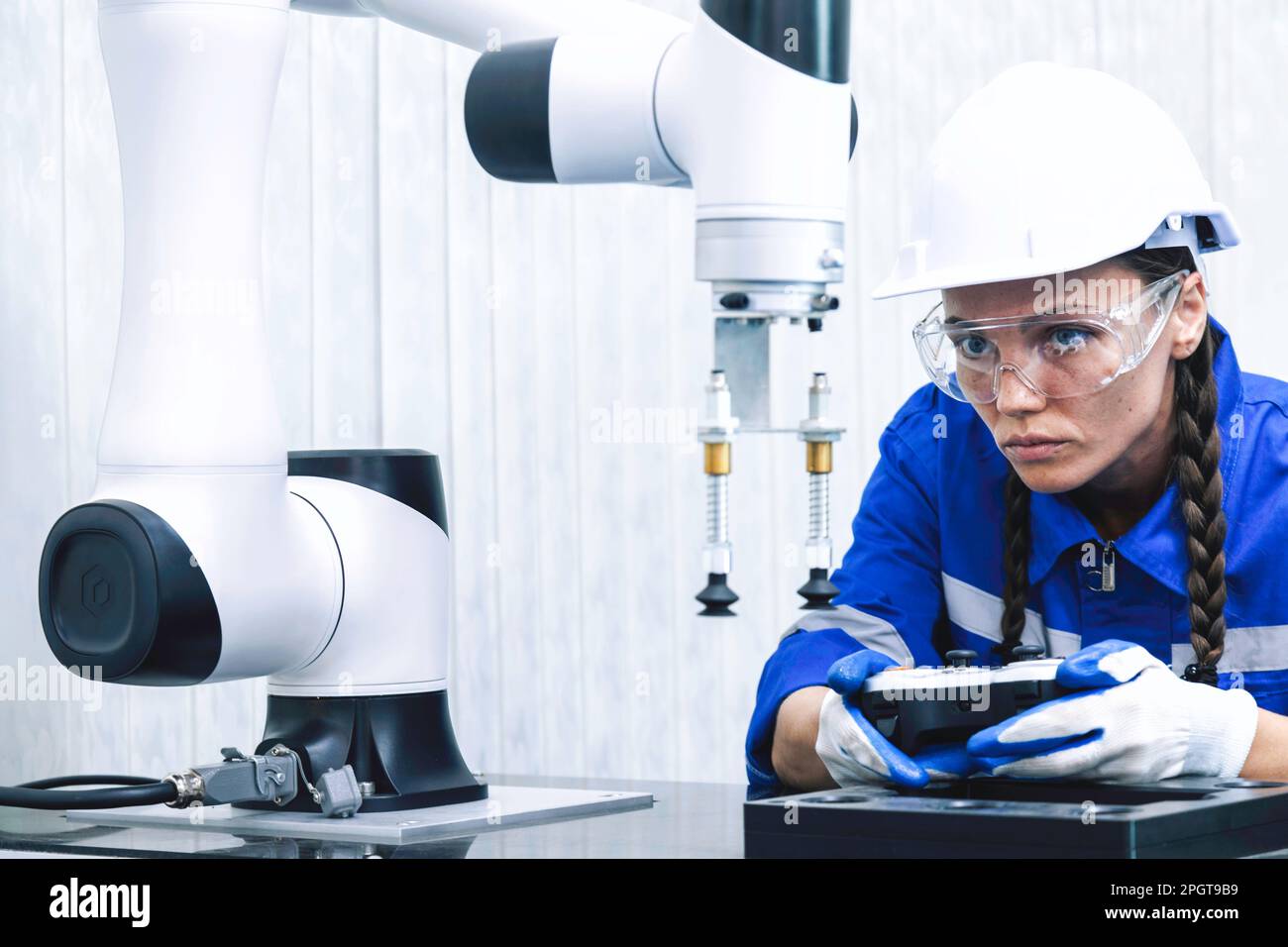 une femme ingénieur en machine d'automatisation étudie et contrôle la machine à bras robotisé dans l'université ou l'atelier d'usine. technologie robot ai nouveau i Banque D'Images