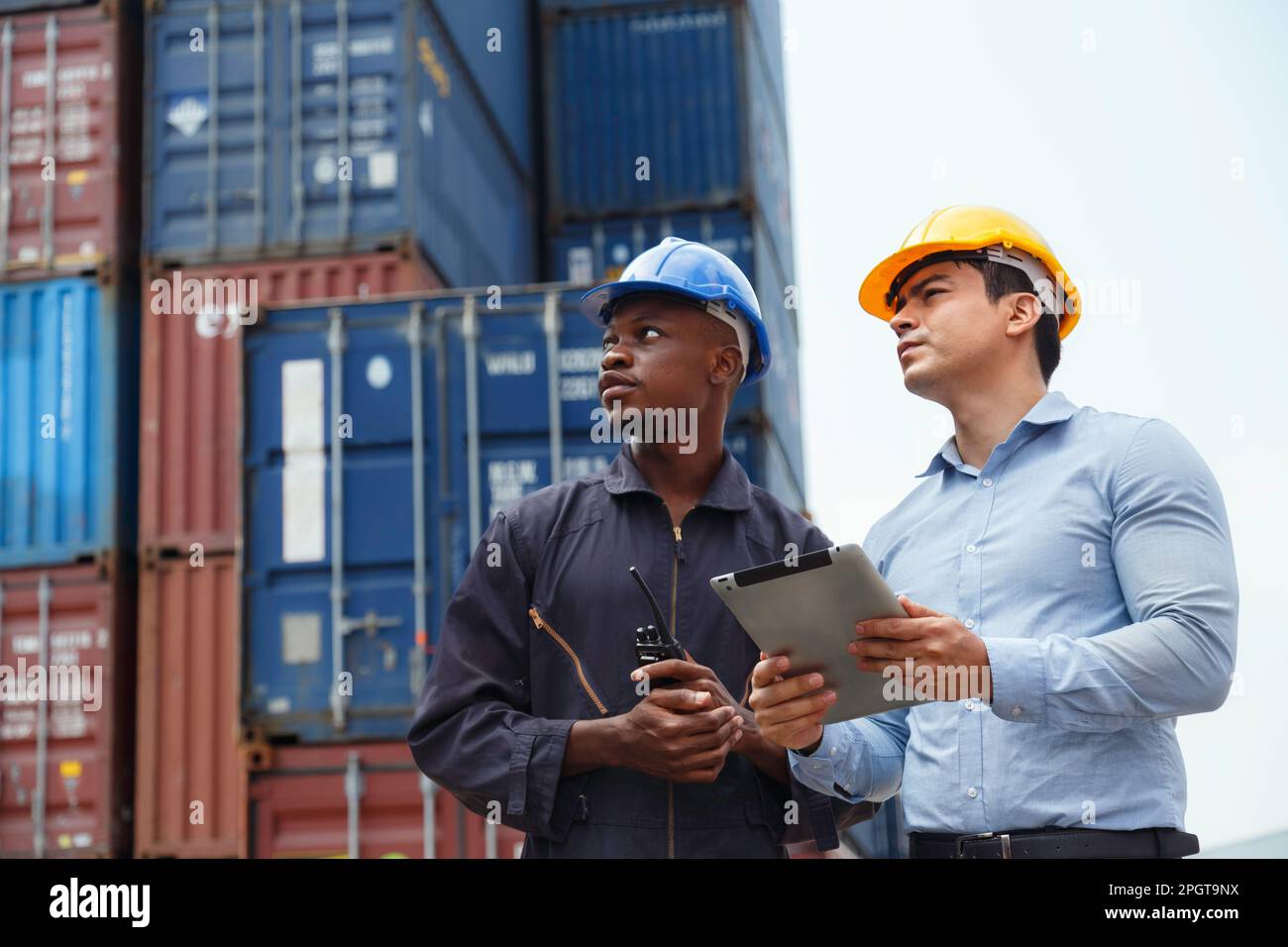 Le directeur d'entreprise de l'entrepôt et l'employé du port qui travaille et vérifie le conteneur après le chargement dans le port commercial. Logistique, transport, importation et exp Banque D'Images