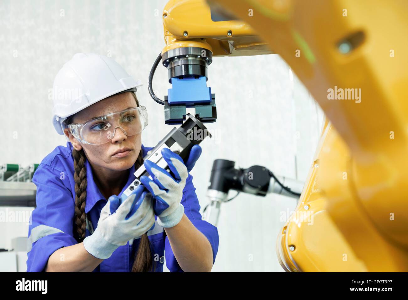 une femme ingénieur en machine d'automatisation étudie et contrôle la machine à bras robotisé dans l'université ou l'atelier d'usine. technologie robot ai nouveau i Banque D'Images