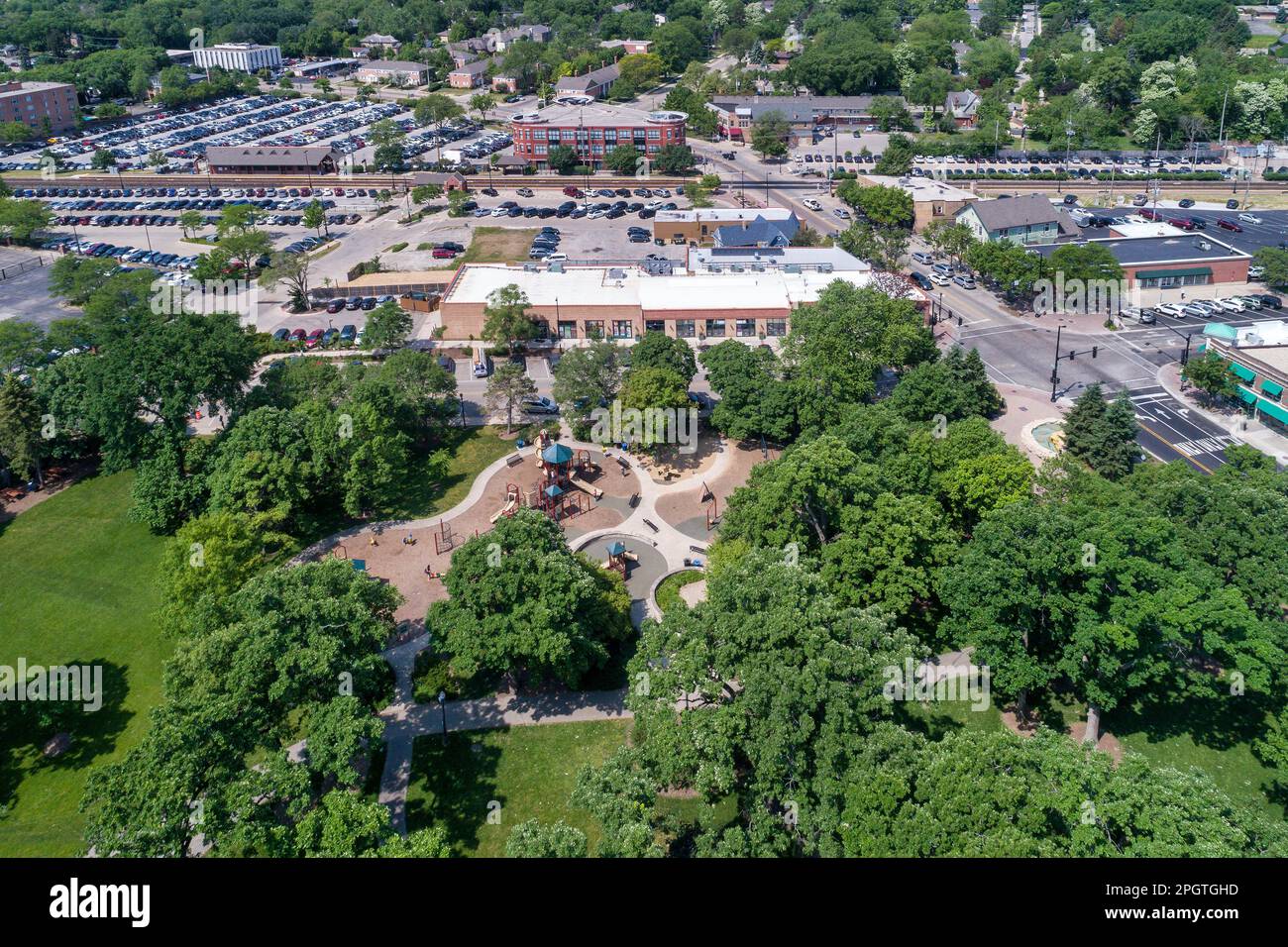 Vue aérienne d'un terrain de jeu et d'un parc adjacent à un quartier d'affaires avec des magasins et un train de banlieue à Northbrook, Illinois. Banque D'Images