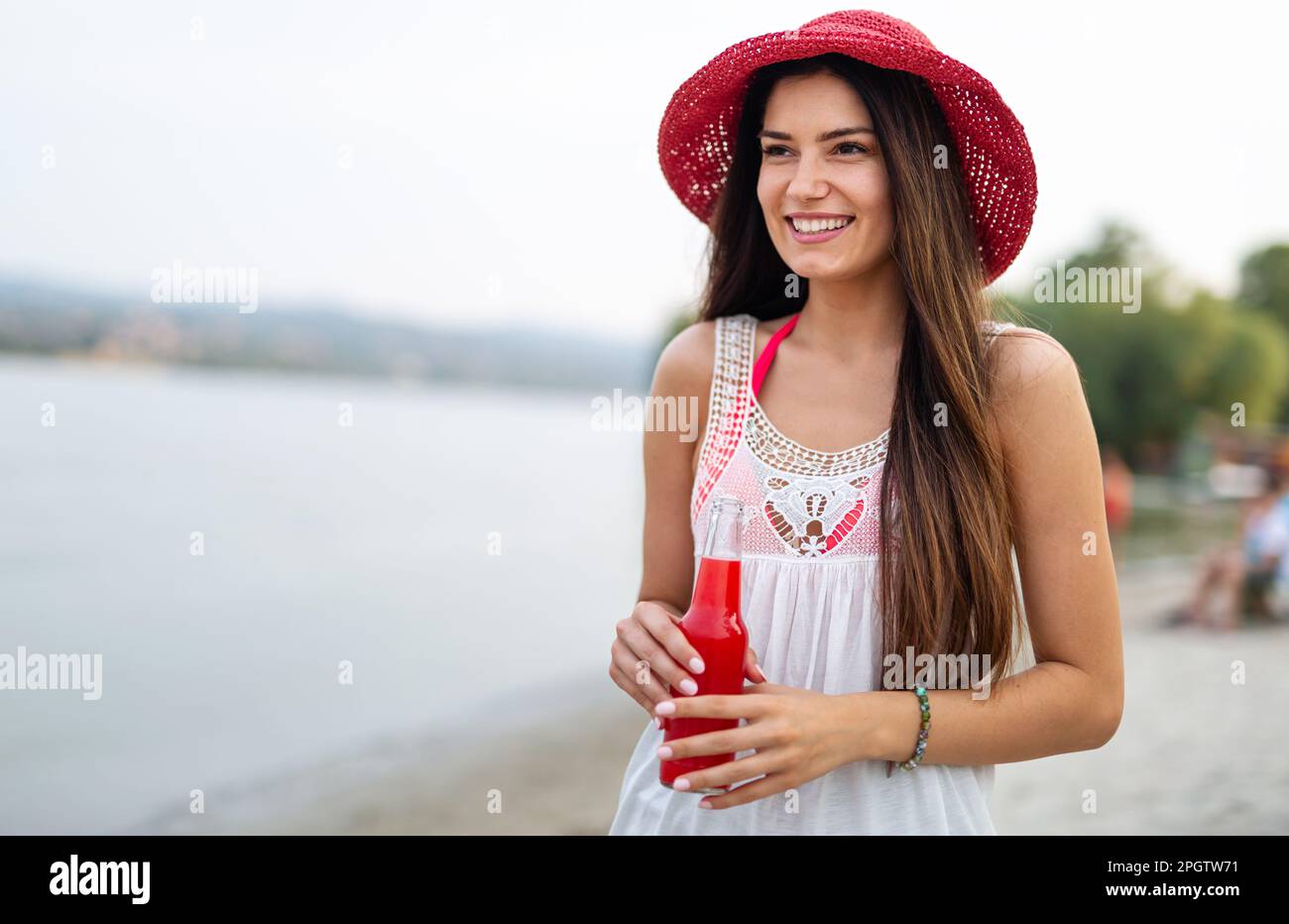 Portrait d'une femme heureuse qui boit un cocktail en été et qui profite de ses vacances Banque D'Images