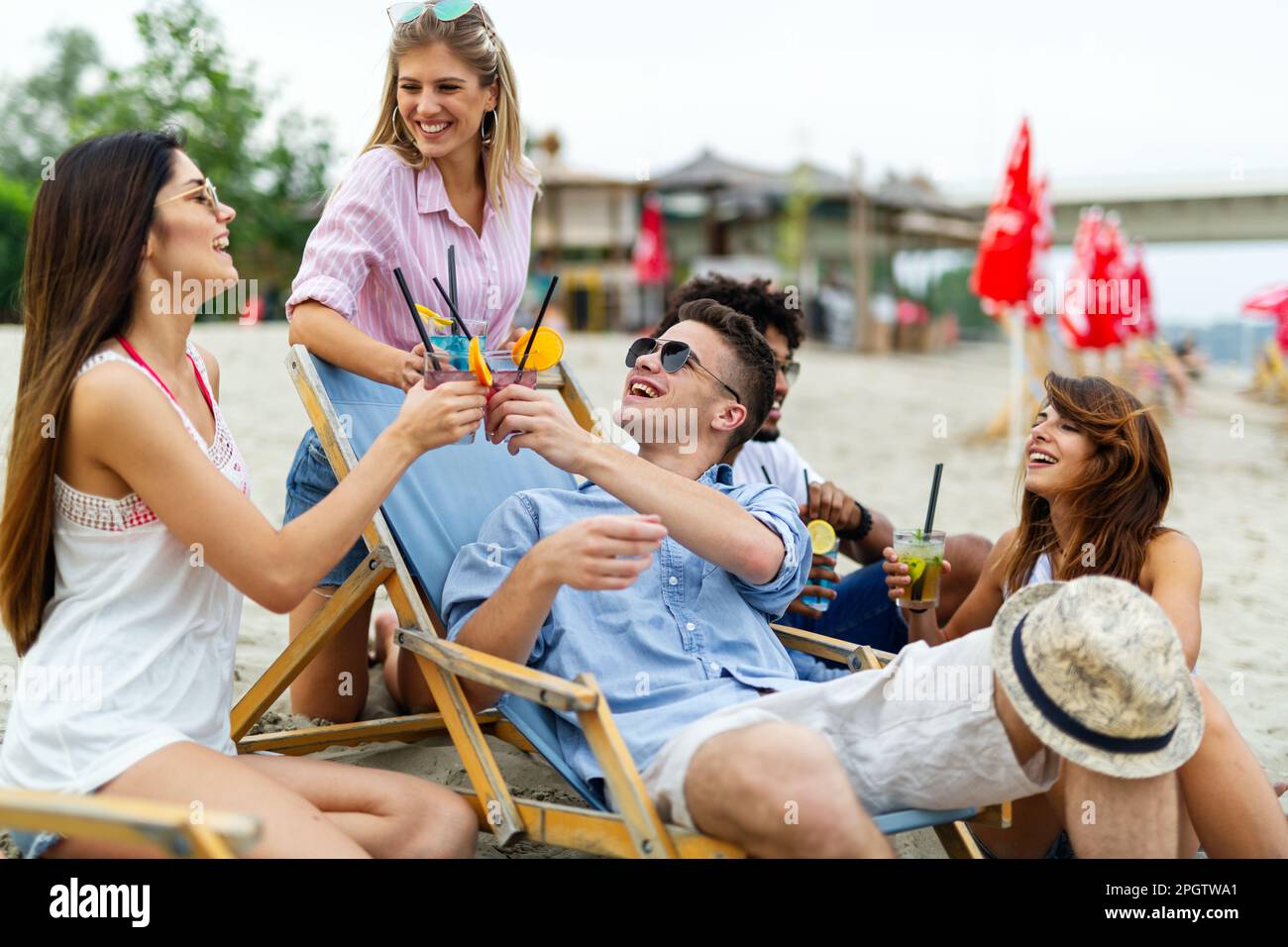 Groupe de jeunes amis qui s'amusent à la plage par une journée ensoleillée. Personnes vacances bonheur concept. Banque D'Images