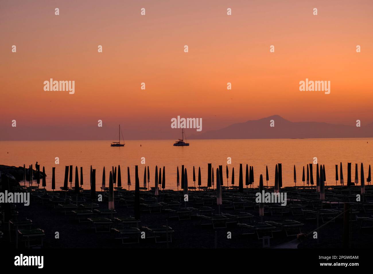 Deux navires dans la mer de coucher de soleil, les montagnes, et le soleil lit sur la plage à Sestri Levante, Ligurie, Italie. Arrière-plan d'été Banque D'Images