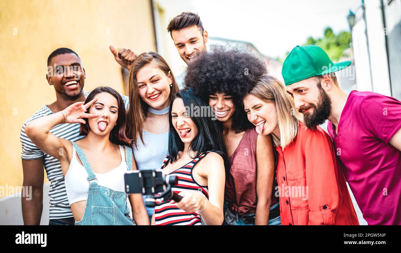 Amis multiraciaux prenant le selfie vidéo avec le téléphone mobile sur stabiliser le gimbal - diverses personnes s'amusant sur la nouvelle tendance technologique - concept de style de vie Banque D'Images