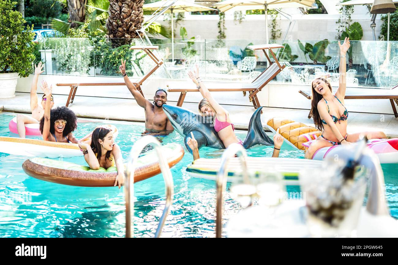 Jeunes gens de fantaisie s'amuser à la piscine partie avec lilo airbed et vêtements de natation - concept de style de vie de luxe avec des hommes et des femmes heureux appréciant summ Banque D'Images