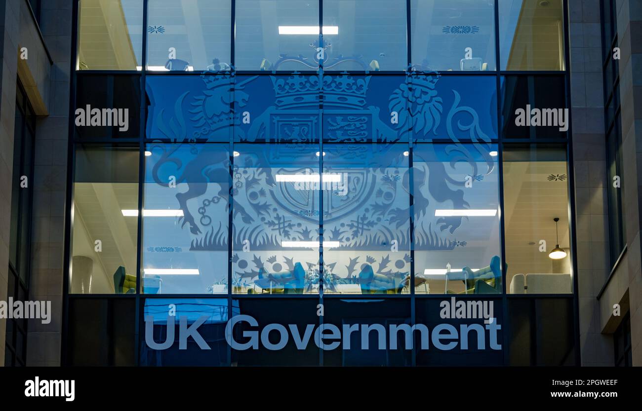 Les fenêtres du bâtiment du gouvernement britannique sont illuminées la nuit avec des armoiries, Edimbourg, Écosse, Royaume-Uni Banque D'Images