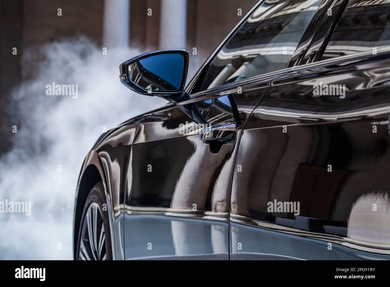 Vue rapprochée du panneau latéral brillant d'une Audi et du rétroviseur. Banque D'Images