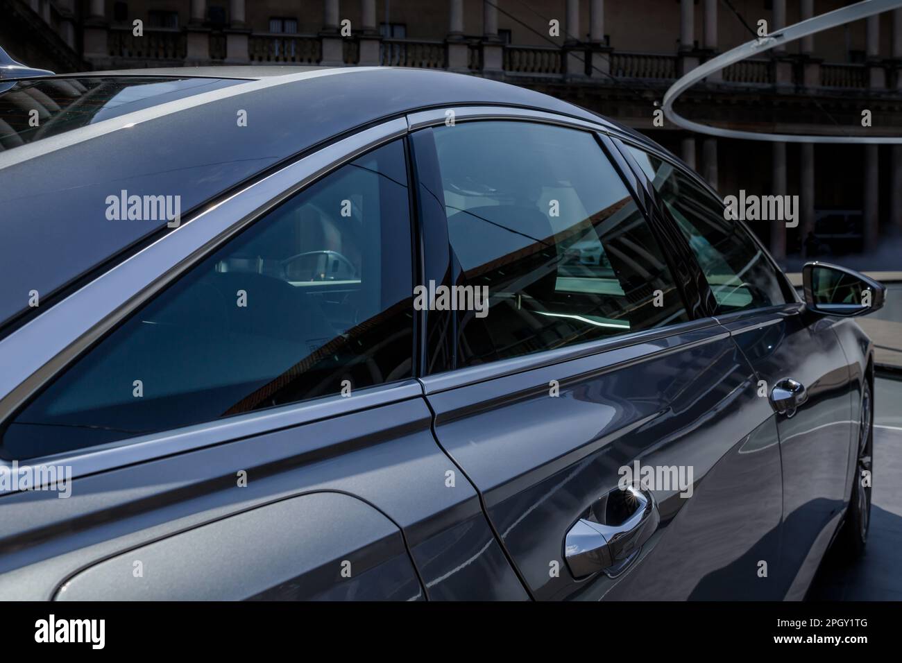 Vue rapprochée du panneau latéral brillant d'une Audi et du rétroviseur. Banque D'Images