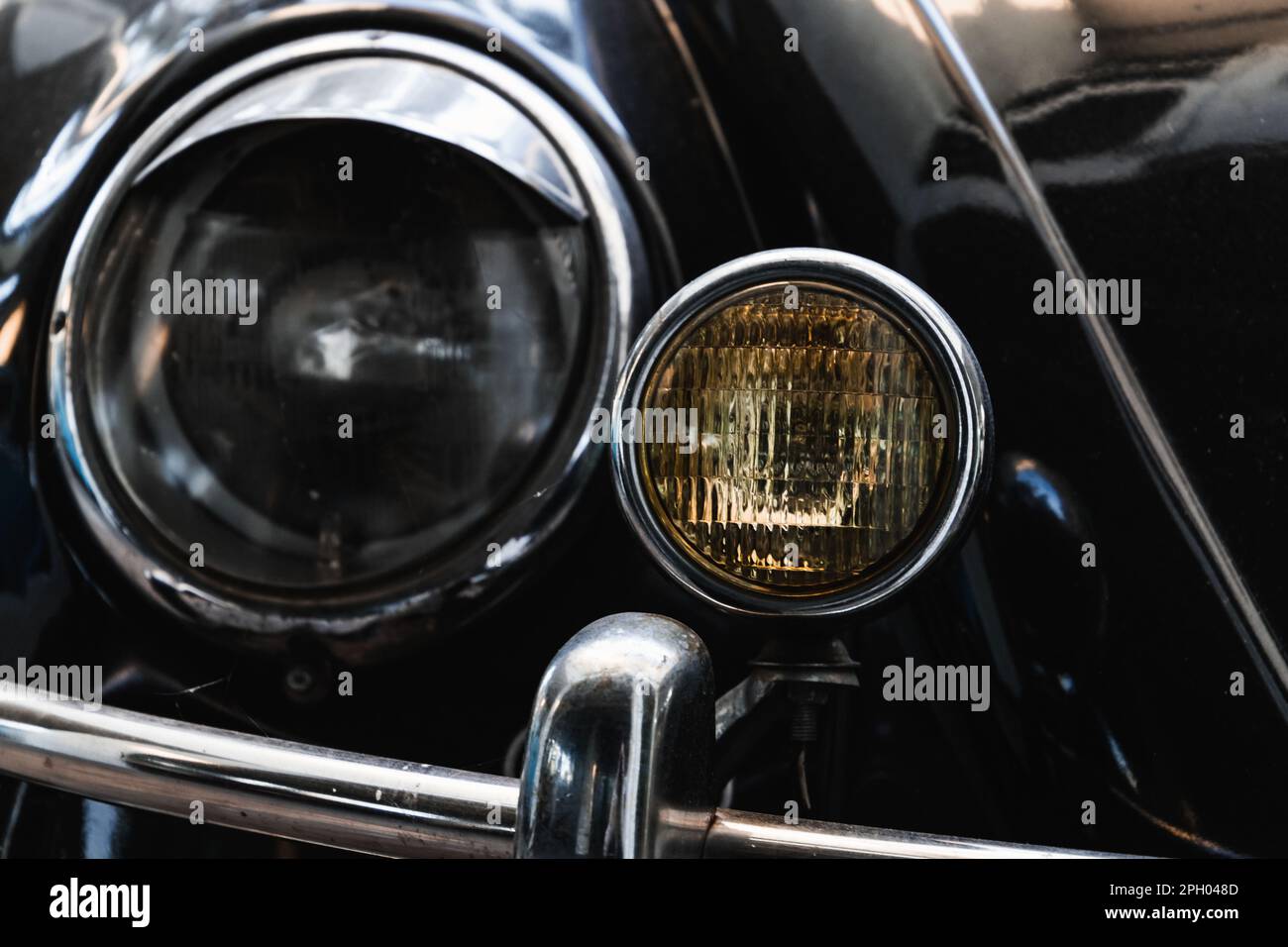 Phares ronds d'une voiture noire vintage. Gros plan avec mise au point douce et sélective Banque D'Images